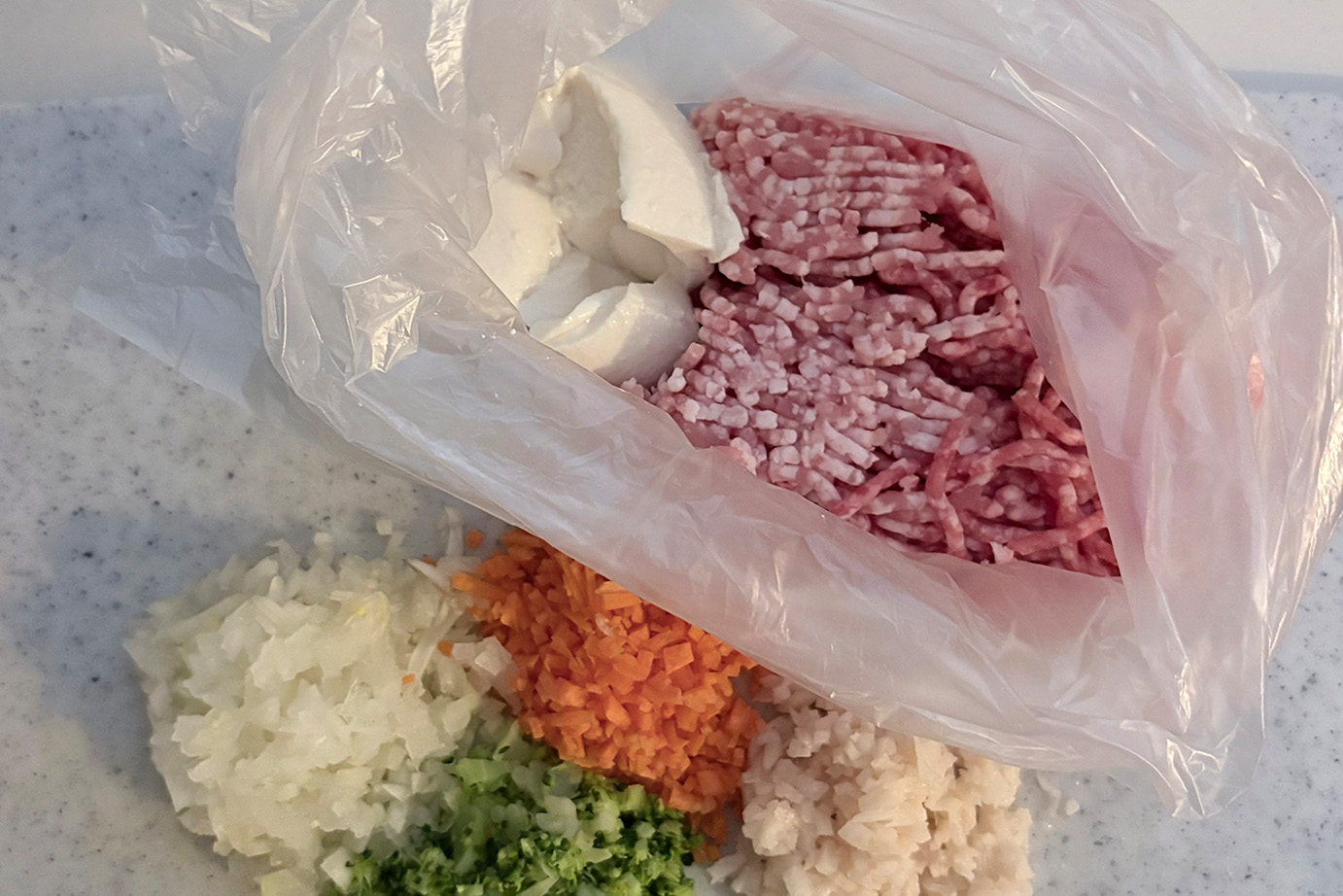 袋に入った肉と豆腐、外に野菜。